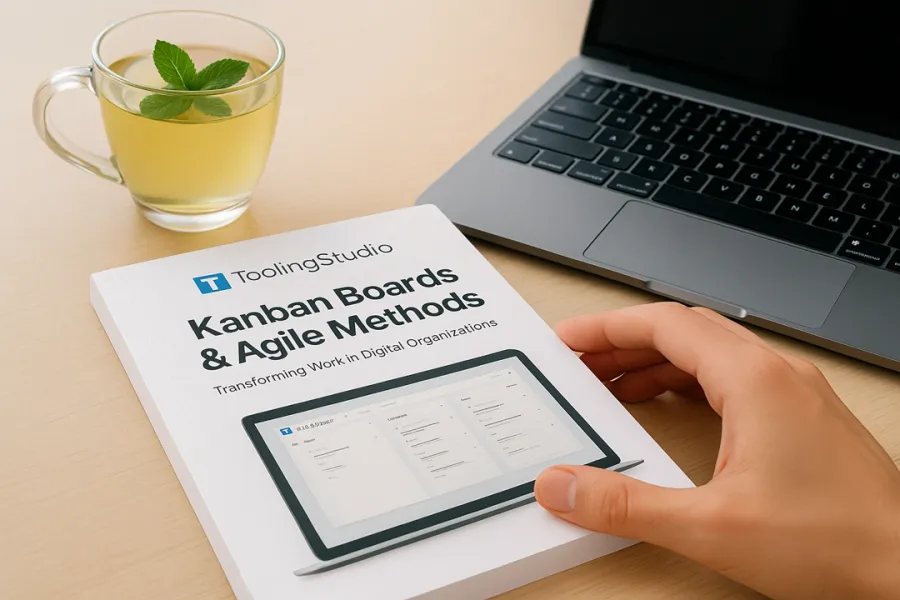 kanban book lying on table with tea and macbook